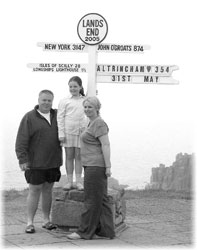 Tourists posing by a signpost at Land’s End.