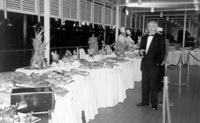 My husband, Josip, surveys the astounding late-night pool deck buffet with its creative fruit carvings. 