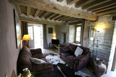 The beamed living room leads out to the sunroom via “French” doors.