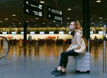 Woman sitting on luggage. 