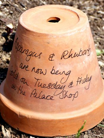 Terra-cotta planting pots inform visitors as to what produce is on sale that day in the palace shop — Kitchen Garden, Hampton Court Palace, Surrey, England.