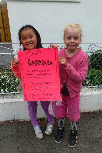 Two local princesses in Akureyri removing a yard sale sign. Photo by Randy Keck